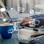 Homem de terno digitando em notebook com vários ícones pela tela em cima de mesa de escritório usando estratégias de marketing digital